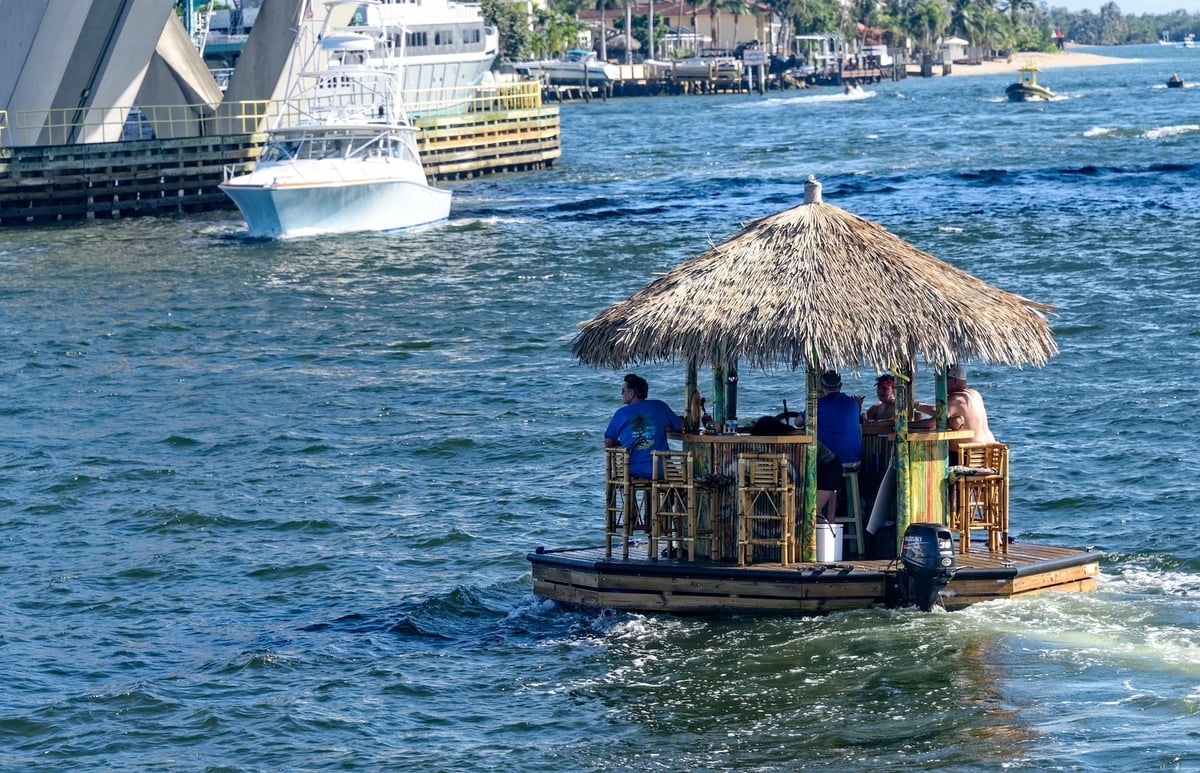 A floating tiki bar boat carrying happy guests along the Fort Lauderdale waterway